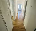 wooden floor, white walls, closed doors, hallway