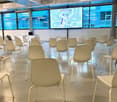 large open room, many white chairs, projector screen, large windows