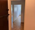 Empty room, wooden parquet flooring, two doors, beige wall, one door with lock