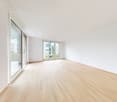 Open room, wooden floors, sliding glass doors, white walls, balcony