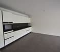kitchen area with modern appliances, white cabinets, black countertops, built-in oven and sink