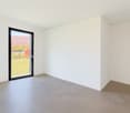 Empty room, glass sliding door, white walls, gray tiled floor, power outlet