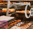 Variety of pastries and breads on display in a bakery case