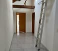 Tiled flooring, white walls, wooden ceiling, ladder, entrance door, two doors