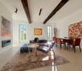 white walls, wooden beams, fireplace, modern furniture, large windows, rug, modern art paintings