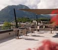 Rooftop terrace with tables and chairs, canopy, beautiful view of mountains and city