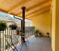 balcony with wooden ceiling, table and chairs, potted plants, metal railing, tiled floor, view of the mountains