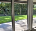 sliding glass doors, balcony, paved floor, lawn, fence, trees