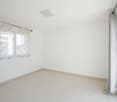 empty room, white walls, white tile floor, two windows with curtains, ceiling light