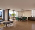modern open-plan living and dining area with large windows, wooden floor, dining table, chairs, balcony, kitchen island, chandelier, rug, coffee table, armchairs, side table