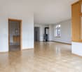 Empty room with wooden floor, white walls, fireplace, door, window