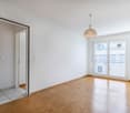 empty room, wooden floor, white walls, sliding glass doors to balcony, ceiling lamp