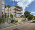 Residential building with multiple balconies, garage, fenced garden, street view