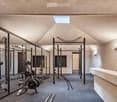 Home gym room with weight training equipment and mirrors.
