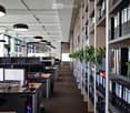 office with long corridor, wooden floors, desk, computer monitors, cabinets, indoor plants