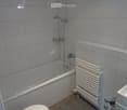 Bathtub, shower, sink, tile flooring, toilet, heater