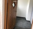 room with a wooden door and tiled floor