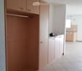 Large built-in wardrobe, cabinets, counter with electric outlets, and dishwasher.