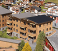Apartment complex, 4 floors, wooden exterior, solar panels, balconies, green lawn