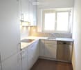 modern kitchen with granite countertop, dishwasher, washing machine, window, bright