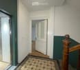 elevator, wooden handrail, tiled floor, white walls, wooden floor