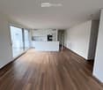 wooden floor, white walls, kitchen island, large sliding doors leading to a balcony