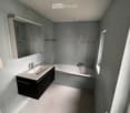 Bathroom with white sink, mirror, bathtub, and shower