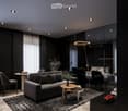 Modern living room with black furniture and beige wooden floor, large grey sofa, round wooden coffee table, potted plants, floor lamp, carpet, and round mirror.