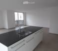 Kitchen. Modern kitchen with white cabinets, black countertop, and stainless steel sink.