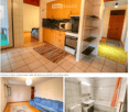 The image shows a furnished apartment with a living room, kitchen, and bathroom. The living room features a blue sofa and a patterned rug. The kitchen has wooden cabinets, a microwave, and an oven. The bathroom includes a sink, bathtub, toilet, and a mirr