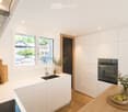 Modern kitchen with white cabinets, a central island, and a sink. Features include a built-in oven, a wooden cutting board, and decorative vases with plants.