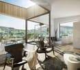 Modern living room with large windows offering a scenic view, featuring a sofa, coffee table, chairs, and a floor lamp.