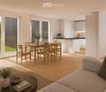 Bright, open-plan living and dining area with light wood flooring, large windows, and a balcony view. Features a sofa, coffee table with books and a vase, dining table with chairs, and a modern kitchen area with cabinets and a counter.