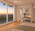 Bright bedroom with wooden flooring, large windows opening to a balcony with city view, side table with lamp, potted plant, and decorative candle holder.