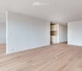Empty room with light wooden flooring and white walls. No furniture or equipment visible.