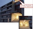 Multi-story building with modern design, large windows, illuminated entrance, and balconies on the top floor.
