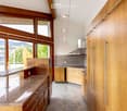 Modern kitchen with wooden cabinets, granite countertop, stainless steel range hood, and pendant lighting.