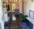 A modern hallway with dark tiled flooring, a purple hanging chair, a small table with a plant, a mirror, and a decorative rug with a heart design.