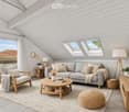 Bright living room with white shiplap walls, skylights, grey sofa, wooden coffee table, armchair, ottoman, floor lamp, side table, and decorative plants.