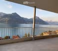 Balcony with a scenic mountain and lake view, featuring a metal railing and tiled floor.