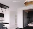 Modern open-plan living space with a kitchen area, dining table, and a separate bedroom area with a bed and lamp.