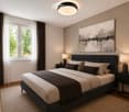 Modern bedroom with a large bed, nightstands, lamps, and a large abstract painting on the wall. The room features wooden flooring and large windows with curtains.