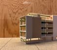 3D model of a multi-story building with balconies, green supports, and a modern design.