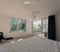 Bright bedroom with large windows, a neatly made bed, and a pendant light fixture.