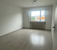 Empty room with white walls, hardwood flooring, and a window overlooking the exterior.