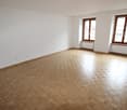 empty room with white walls, wooden parquet flooring, two windows