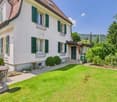2 story house, white exterior, green shutters, red roof, garden, mountain view