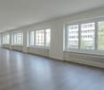 empty room, wooden floor, white walls, large windows, radiators