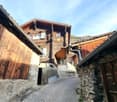2 story wooden chalet-style house with stone and wood exterior, balcony, and decorative star on the roof