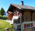wooden chalet, brown roof, wooden exterior, red shutters, wooden chimney, outdoor view, piles of wood